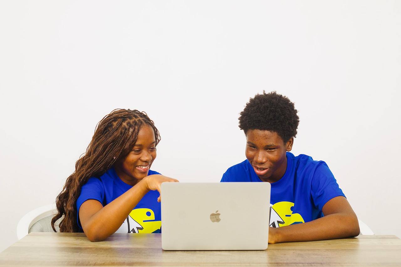 CJpy Cohort students working together at a laptop